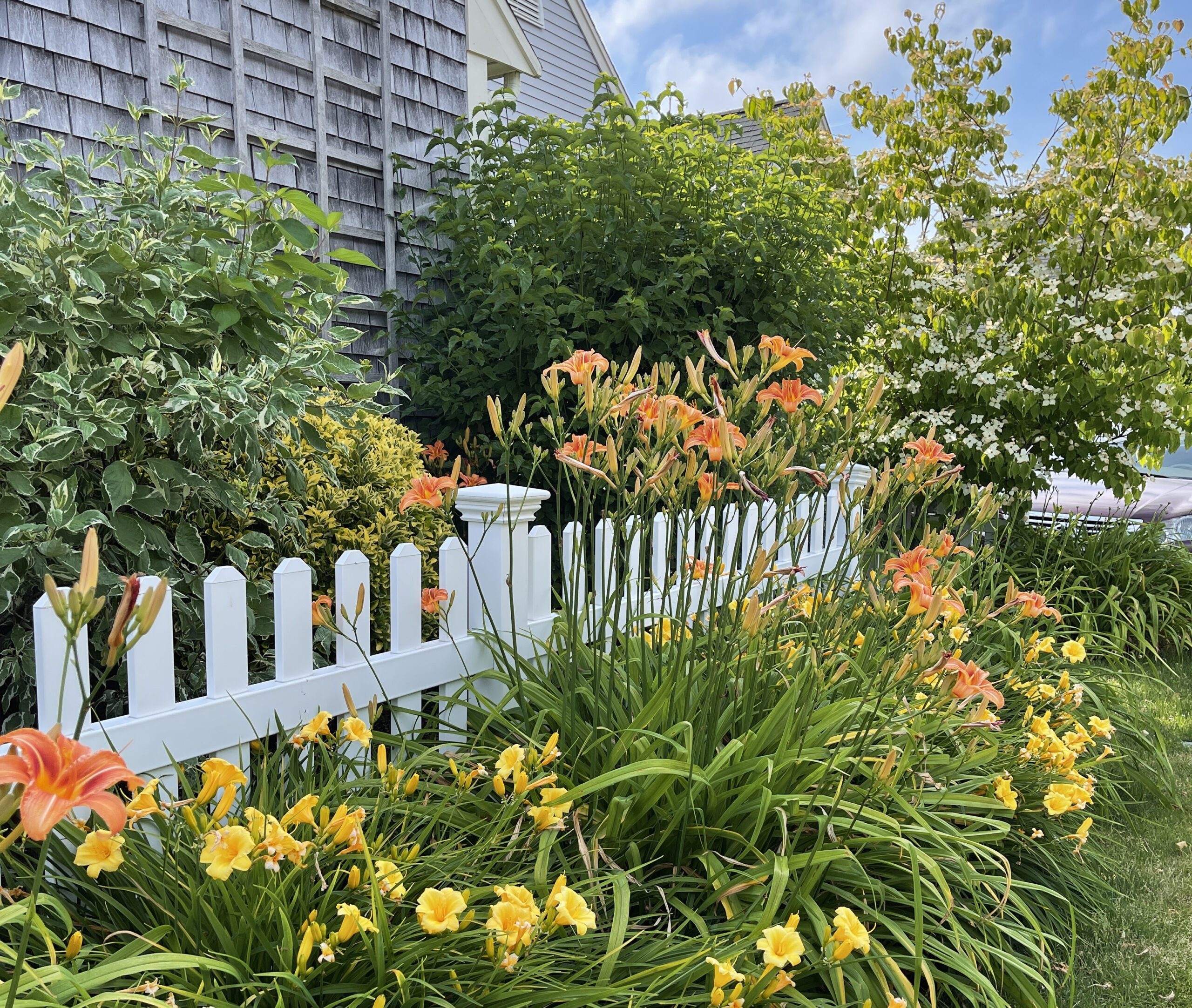 Flower garden and white picket fence of Windchime home